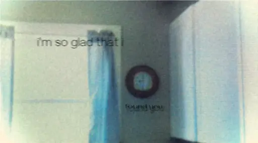 overexposed corner of a room, with white cabinets on the right, a bright window with blue curtains on the left, and a clock in the middle. black text reads "i'm so glad that i found you" 