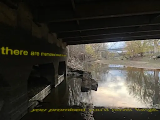 Creek meandering under a medium sized bridge. Dull yellow text reading "there are memories beneath the surface" fades into the concrete. In the murky water are the words "you promised you'd never forget"